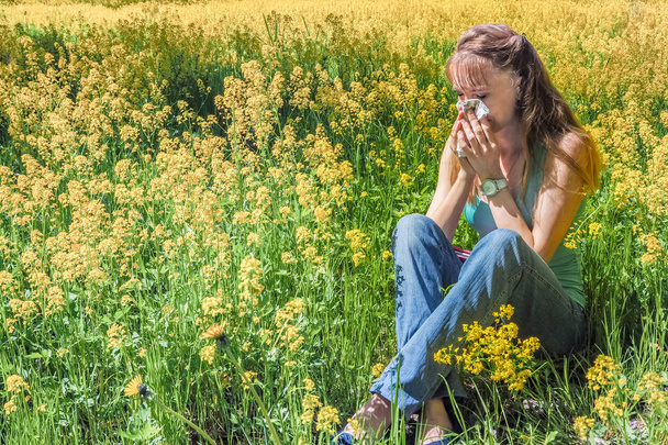 Reacciones alérgicas a las flores de primavera, polen, ambrosía. Alergia estacional. Mujer sonándose la nariz en el parque de primavera de fondo
. - Foto, Imagen