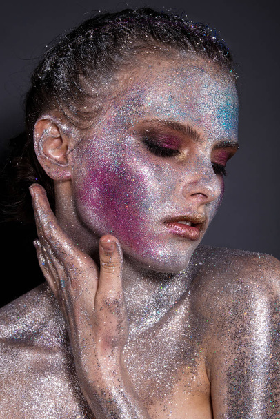 Fashion model with bright makeup and colorful glitter and sparkles on her face and body. - Fotoğraf, Görsel