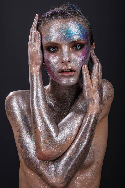Fashion model with bright makeup and colorful glitter and sparkles on her face and body. - Фото, зображення
