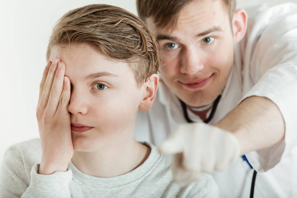 視力検査の時に医師に立って後ろ十代の少年 - 写真・画像