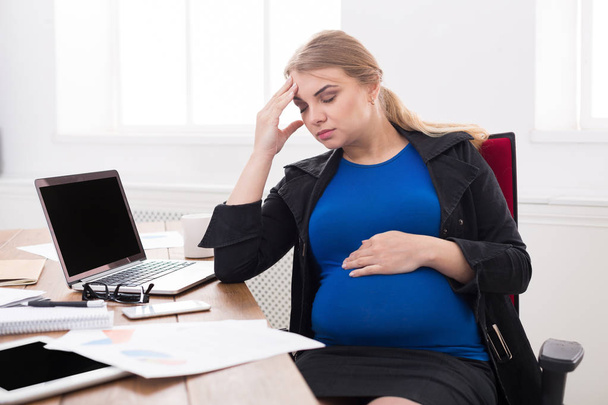 Tired pregnant businesswoman at office copy space - Fotoğraf, Görsel