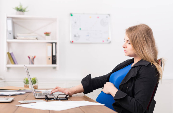 Kobieta w ciąży działa na laptopie w biurze - Zdjęcie, obraz