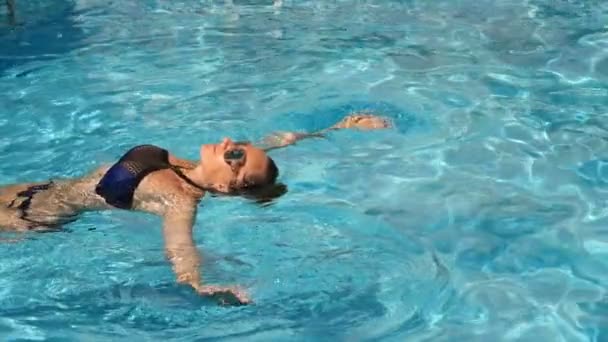 Mujer guapa rubia disfrutando del agua en la piscina. Vista desde arriba. Movimiento lento
 . - Metraje, vídeo