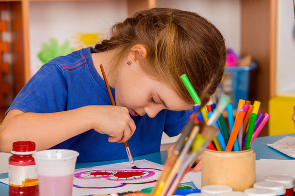 Small students girl painting in art school class. - 写真・画像
