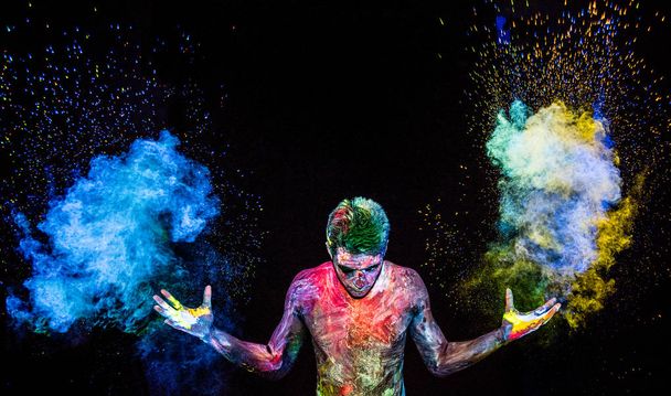 Man throwing up glowing powder - Foto, afbeelding
