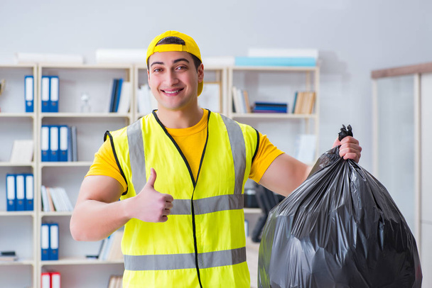 Hombre limpiando la oficina y sosteniendo la bolsa de basura - Foto, Imagen