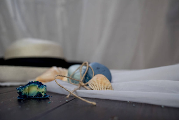 Straw hat with blue macaroons and sea salt with shells on the wood background - Фото, изображение