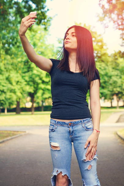 Mladá žena SMS na mobilní telefon venku - Fotografie, Obrázek