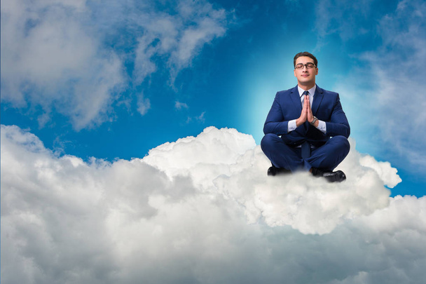 Businessman meditating in the sky - Photo, Image