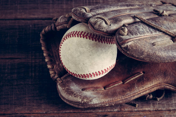 old Baseball and glove on wood background with filter effect retro vintage style - Foto, afbeelding