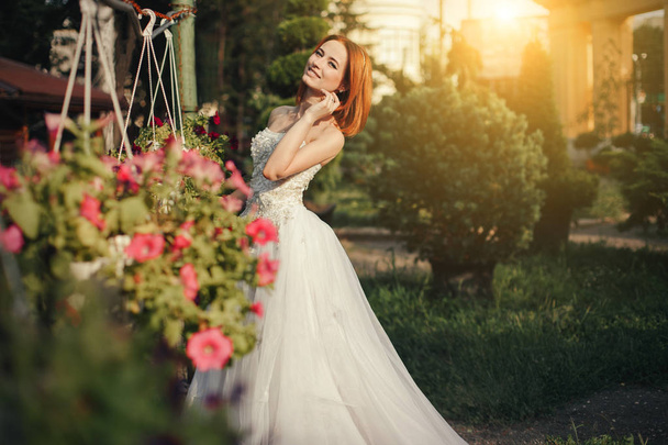 Beautiful young bride posing in a park - 写真・画像