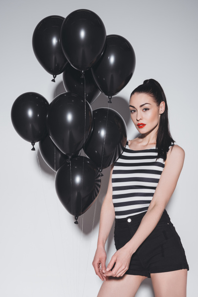 Donna elegante con palloncini neri
 - Foto, immagini