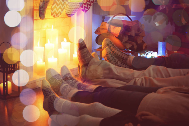 Family lying together on floor near fireplace. Christmas and New Year 2018 celebration - 写真・画像