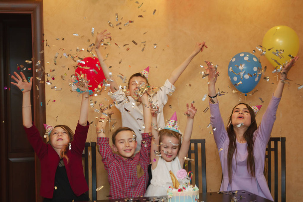 子供たちは子供たちのパーティーで紙吹雪を投げます。子供たちは、家族の休日に一緒に楽しい時を過す. - 写真・画像