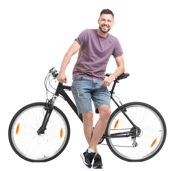 Handsome young man with bicycle on white background - Foto, Bild