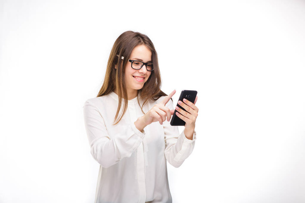 Portrait femme heureuse et souriante textant sur son téléphone intelligent, fond blanc isolé. Concept de communication. Internet, dépendance au téléphone
 - Photo, image