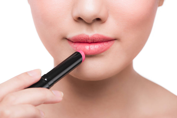 woman applying pink lipstick - Foto, afbeelding
