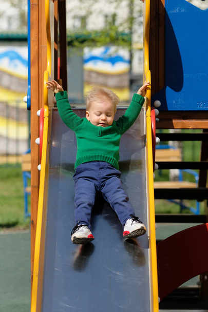 toddler boy at playground slide - Fotó, kép