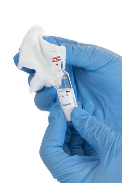 Geneeskunde fles voor injectie in de hand van de verpleegkundige of Arts. Medische glazen ampul voor vaccinatie. - Foto, afbeelding