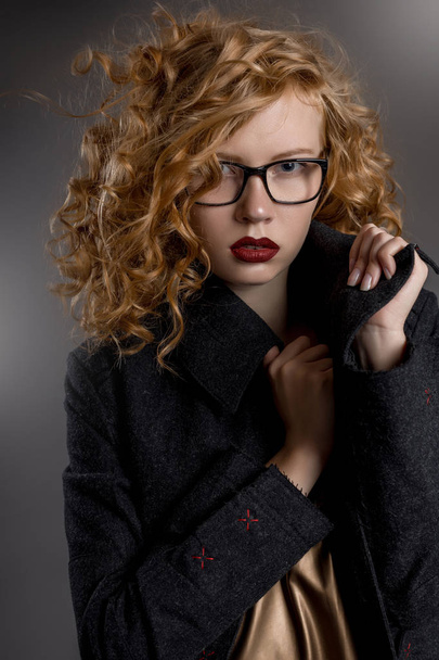 Красива волохата дівчина в пальто і окулярах
 - Фото, зображення