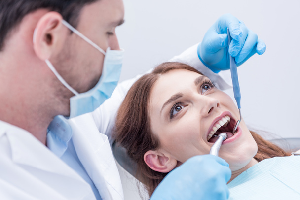 Dentista cura los dientes de los pacientes - Foto, Imagen