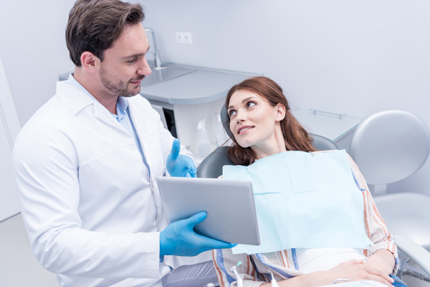 Zahnarzt diskutiert Behandlung mit Patient - Foto, Bild