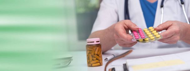 Naislääkäri, jolla on läpipainopakkaus pillereitä
 - Valokuva, kuva