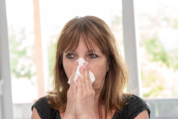 donna soffiando il suo naso - Foto, immagini