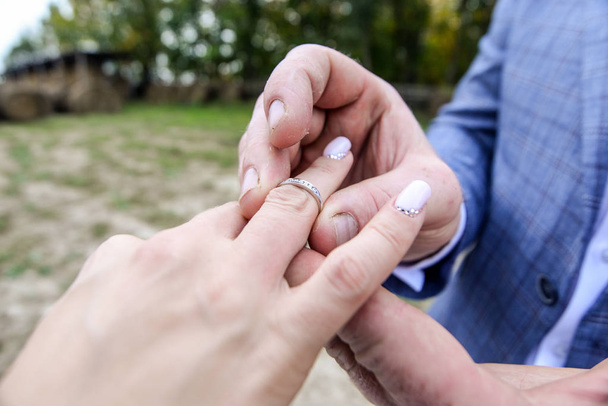 manželství ruce s kroužky. Birde nosí prsten na prst ženicha - Fotografie, Obrázek