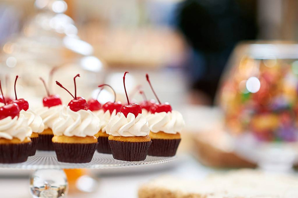 Plate full of cupcakes with cream and cherry on top - Fotografie, Obrázek