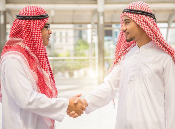 Arab and businessman are shaking hand on cityscape background, Business Successful concept. - Photo, Image