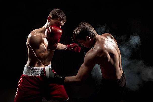 Two professional boxer boxing on black smoky background, - Foto, immagini