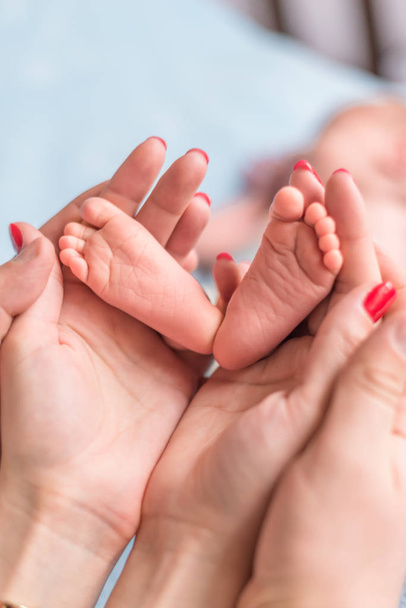 Bebe ayak anne elinde. Küçük yeni doğan bebek ayağa şekillendirilmiş closeup eller erkek. Anne ve çocuk. Mutlu aile kavramı. Annelik güzel kavramsal görüntüsü - Fotoğraf, Görsel
