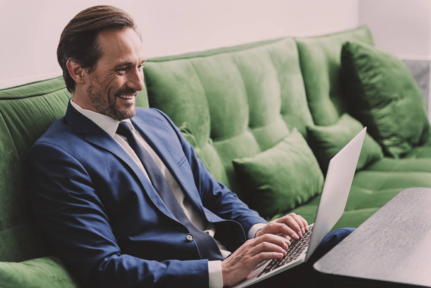 Positive senior man using laptop for business work - Valokuva, kuva