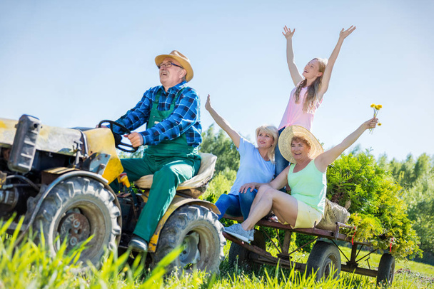 muž vezme rodinu pro jízdu na traktoru - Fotografie, Obrázek