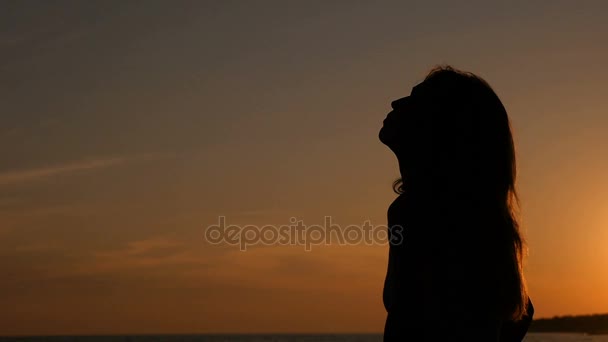 Relaxujte při západu slunce: osamělá žena uvolňuje sledovat západ slunce - Záběry, video