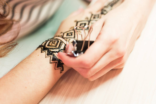 fiatal nő mehendi művész festés henna a kezét - Fotó, kép