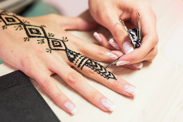 Processo di disegno di hennè menhdi ornamento sulla mano delle donne
. - Foto, immagini