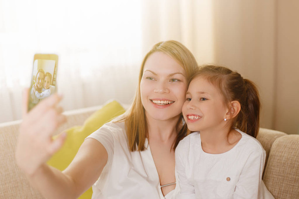 Beautiful mother and yound daughter making a selfie. - Foto, Bild