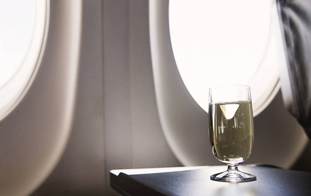 glass of wine in the plane - Фото, изображение