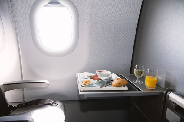 Comida servida a bordo de un avión de clase ejecutiva sobre la mesa
 - Foto, imagen