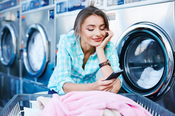 Frau nutzt App zum Wäschewaschen - Foto, Bild