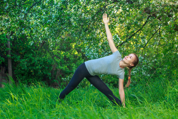 Kaunis nainen joogaa ulkona vihreällä ruoholla
 - Valokuva, kuva