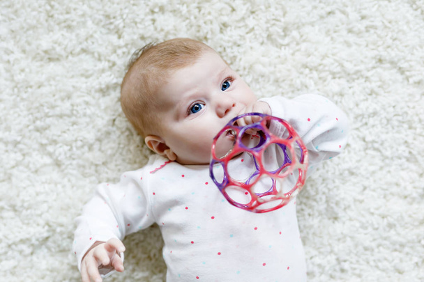 Schattig baby meisje spelen met kleurrijke rammelaar speelgoed - Foto, afbeelding