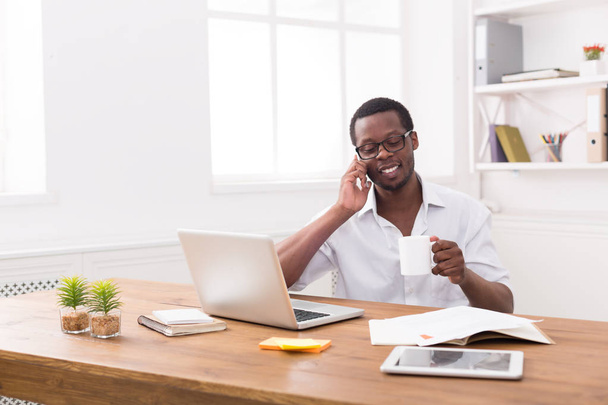 Young black businessman call mobile phone in modern white office - Photo, Image