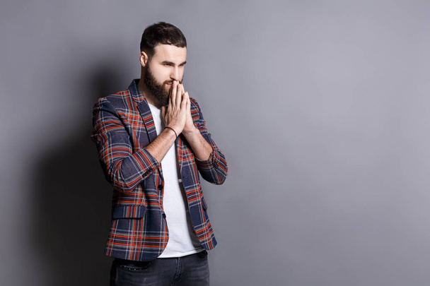Portrait of hopeful bearded hipster praying - Photo, Image