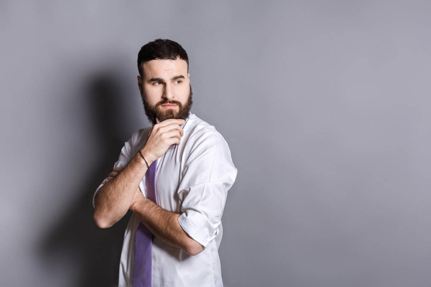 Pensive bearded businessman with hand on chin - 写真・画像