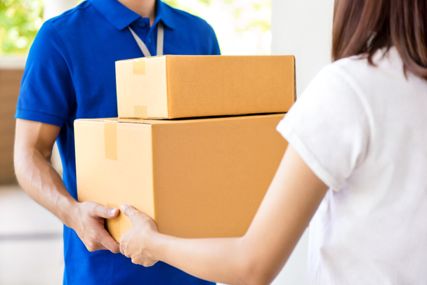 Deliveryman csomagküldő doboz adva egy nő - Fotó, kép
