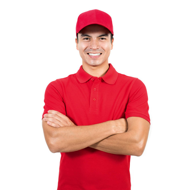 Lächelnder Auslieferer in roter Uniform mit verschränktem Arm - Foto, Bild