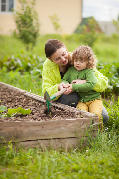 Mother and daughter working in the domectic garden - Photo, image